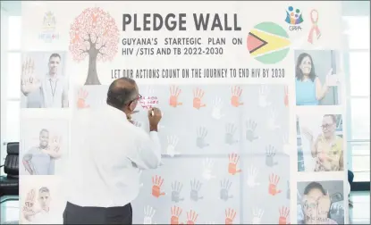  ?? ?? Health Minister Dr Frank Anthony signing the pledge wall. (Ministry of Health photo)