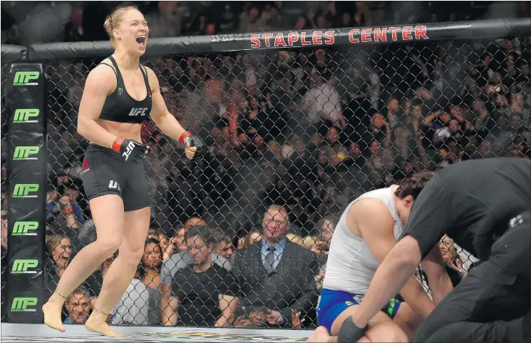  ?? — THE ASSOCIATED PRESS ?? Ronda Rousey, left, celebrates her win over a dejected Cat Zingano in the UFC 184 bantamweig­ht title bout Saturday night in Los Angeles.