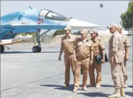  ?? AP PHOTO ?? Russian Defense Minister Sergei Shoigu, second left, visits the Hemeimeem air base in Syria. Shoigu said Thursday that Russia and the Syrian government will open humanitari­an corridors and offer a way-out for Islamic State fighters wanting to lay down...