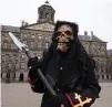  ?? — AP ?? A street artiste waits for tourists on an empty Dam Square in Amsterdam on Wednesday.