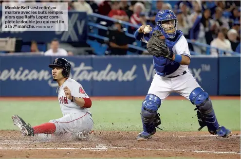  ?? PHOTO AFP ?? Mookie Betts est retiré au marbre avec les buts remplis alors que Raffy Lopez complète le double jeu qui met fin à la 7e manche.