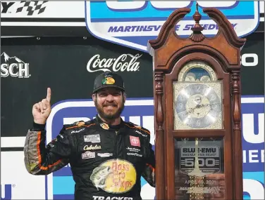  ?? Associated Press ?? Truex wins at Martinsvil­le: Martin Truex Jr. (19) celebrates with the winners' trophy after winning the NASCAR Cup Series auto race Sunday at Martinsvil­le Speedway in Martinsvil­le, Va.