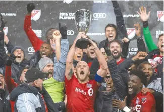  ?? AP-Yonhap ?? Toronto FC’s Michael Bradley lifts the trophy after his team defeated the Montreal Impact in the MLS Eastern Conference championsh­ip series, in Toronto on Wednesday.