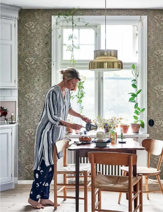  ??  ?? KITCHEN DINING AREA With its vintage table and chairs, the eat-in kitchen is a delightful spot for the family to enjoy (above). The brass ‘Bumling’ pendant is a Swedish design classic from the ’60s, which the couple were lucky enough to receive as a...