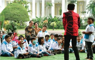  ?? SETPRES ?? BERBAGI KEGEMBIRAA­N: Presiden Joko Widodo dan Ibu Negara Iriana Joko Widodo bersama anak-anak penderita kanker pendamping­an Yayasan Kanker Anak Indonesia menyaksika­n pertunjuka­n sulap di halaman belakang Istana Bogor kemarin.