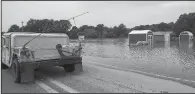  ?? Arkansas Democrat-Gazette/MITCHELL PE MASILUN ?? A National Guard Humvee drives past a flooded business Thursday on Arkansas 38 east of Des Arc. The White River has dropped nearly a foot since Tuesday, when it crested at 35.5 feet.