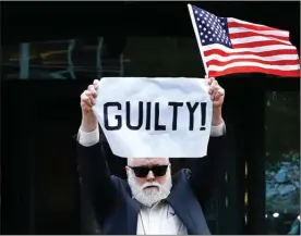  ?? The Associated Press ?? Protester Bill Christeson holds up a sign as the first count of guilty comes in at the trial of former Donald Trump campaign chairman Paul Manafort Tuesday at federal court in Alexandria, Va.