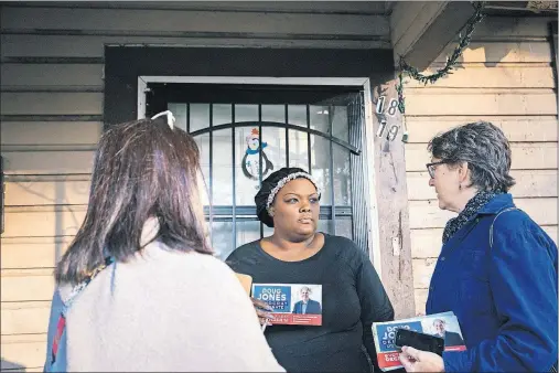  ?? [AUDRA MELTON/THE NEW YORK TIMES] ?? Elena Mason, center, talks with canvassers for Democratic Senate candidate Doug Jones from her home in Anniston, Alabama. Many experts say that it’s crucial for black residents, who make up more than half of the Democratic electorate in Alabama, to get out and vote if there’s a chance of defeating Republican Roy Moore.