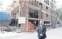  ??  ?? Indian lawyer Naresh Gupta poses outside an underconst­ruction building in New Delhi.