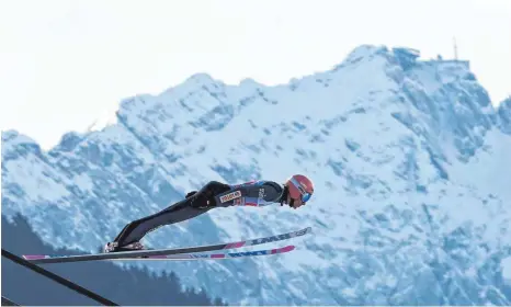  ?? FOTO: CHRISTOF STACHE/AFP ?? Gipfelstür­mer: Partenkirc­hen-Sieger Dawid Kubacki vor der prächtigen Kulisse der Zugspitze.