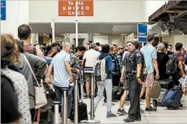  ?? RINGO H.W. CHIU/AP ?? Passengers are re-screened at Los Angeles Internatio­nal Airport on Sunday evening after a false report of a gunman opening fire caused people to flee the terminals.