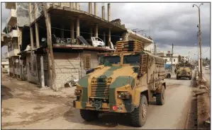  ?? (AP/Ghaith Alsayed) ?? A Turkish military convoy drives through the village of Binnish, Syria, on Saturday as Turkey moves reinforcem­ents into Idlib province.