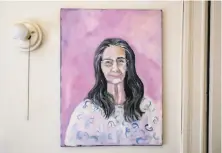  ??  ?? A painting of Maggard hangs in her home. She says she’s a social person and some days alone are good and some are bad.
