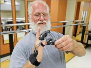  ?? SUBMITTED ?? Navy veteran Fred Fuquay shows the range of motion of his new articulati­ng hand prosthetic during a fit check May 22 at the Central Arkansas Veterans Healthcare System Prosthetic­s Service Clinic.