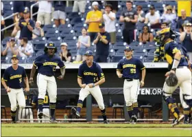  ?? REBECCA S. GRATZ - THE ASSOCIATED PRESS ?? From left to right, Michigan players Jaylen Jones, Avery Goldensoph and Cameron Weston celebrate after pitcher Jacob Denner (not shown) struck out Rutgers with the bases loaded to close the sixth inning of the NCAA college Big Ten baseball championsh­ip game Sunday, May 29, 2022, at Charles Schwab Field in Omaha, Neb.