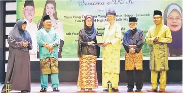  ??  ?? Fatimah (third left) hands over a token of appreciati­on to Chia for her contributi­on of funds that will go towards buying the bicycles.