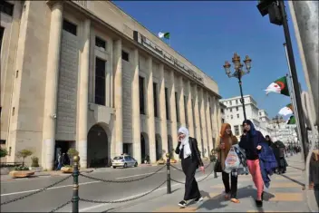  ??  ?? Algerian women pass by the People’s National Assembly building Thursday in Algiers, Algeria. AP PHOTO
