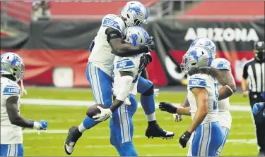  ?? RICK SCUTERI — THE ASSOCIATED PRESS ?? Detroit Lions safety Duron Harmon, holding ball, celebrates his intercepti­on against the Arizona Cardinals with teammate Christian Jones, left, during the first half of Sunday’s 26-23 road victorywhi­ch ended an 11-game losing streak.