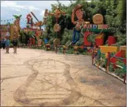 ?? JANET PODOLAK — THE NEWS-HERALD ?? Sheriff Woody welcomes visitors to come play at the new Toy Story Land while Andy is away, The boy’s gym shoe footprint is in the foreground.