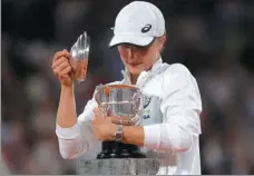  ?? REUTERS ?? Swiatek clutches the cup on Court Philippe Chatrier.