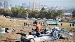  ?? PICTURE: HENK KRUGER ?? CLEANING UP: A homeless man washes himself on a field in District Six.