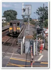  ??  ?? On July 31 1996, 153326 leaves Oulton Broad North forming the 1615 Lowestoft-Norwich train. A white sighting board has been fixed behind the signal arm to improve its visibility. The lifting barriers replaced manually controlled gates and a pedestrian footbridge in 1974.