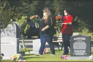  ?? (AP/Gary Kazanjian) ?? Gonzalez and Spray carry flowers to Oldfield’s temporary grave marker.