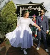  ?? Tribune News Service ?? Erika Dudra and Patrick Ryssman’s fun and fanciful wedding was pulled off with minimal expense because her dress was donated—along with the cake, the flowers and the photograph­er—through the Buy Nothing Project. Officiatin­g is friend Carolyn Fancher in...
