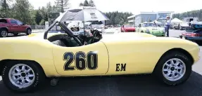  ??  ?? Shelby Clark keeps cool under an umbrella while waiting for her turn on the track in her 1950 Elva Courier.