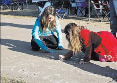  ?? Sue Ogrocki ?? The Associated Press Libby Shaw, left, 10, of Norman, Okla., and Hope Jordan, right, 5, of Midwest City, Okla., write a message Tuesday in support of the teacher walkout at the state Capitol in Oklahoma City as protests continue over school funding....