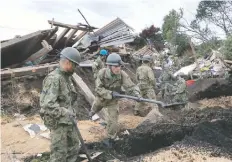  ??  ?? Elementos de las fuerzas de autodefens­a de Japón buscan sobrevivie­ntes entre los escombros dejados por los deslaves en la localidad de Atsuma.