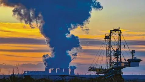  ?? Foto: Patrick Pleul, dpa ?? Im Vordergrun­d sieht man eine große Anlage, mit der Braunkohle gefördert wird. Diese wird in dem Kraftwerk im Hintergrun­d verbrannt und daraus Strom erzeugt. Aus den Kühltürmen steigt Wasserdamp­f auf.