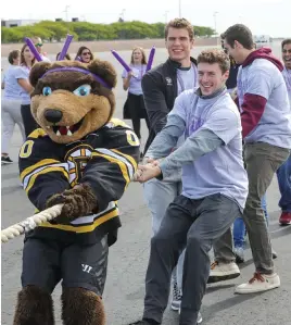  ??  ?? THE LONG HAUL: Boston Bruins mascot Blades helps Team Bruins, above, as Aisha Brown, right, celebrates her team’s victory at Logan Internatio­nal Airport yesterday.