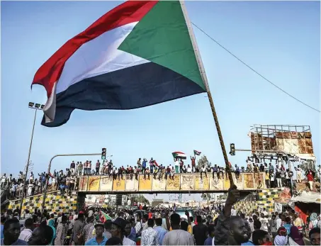  ?? Foto: AFP/Ozan Kose ?? Demonstran­ten schwenken die sudanesisc­he Flagge vor dem Hauptquart­ier des Militärs in Khartum, Sudan.