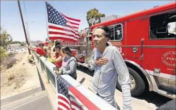  ?? Al Seib Los Angeles Times ?? SHARON JOHNS of Long Beach, right, and others gather on West Willow Street in Long Beach to watch a procession for slain firefighte­r Dave Rosa, whose body was driven to the L.A. County coroner’s office Monday.