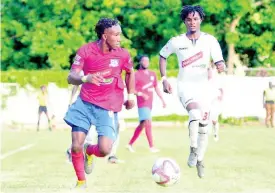  ??  ?? Dunbeholde­n forward Demario Phillips (left) dribbles as UWI defender Damano Solomon tries to close him down during their Red Stripe Premier League fixture at the Royal Lakes field in St Catherine on October 27.