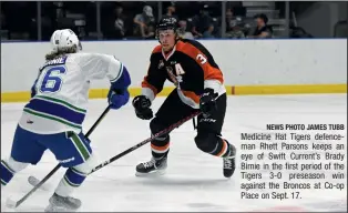  ?? NEWS PHOTO JAMES TUBB ?? Medicine Hat Tigers defenceman Rhett Parsons keeps an eye of Swift Current’s Brady Birnie in the first period of the Tigers 3-0 preseason win against the Broncos at Co-op Place on Sept. 17.