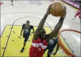  ?? TONY AVELAR — THE ASSOCIATED PRESS ?? Toronto Raptors center Serge Ibaka (9) dunks against the Golden State Warriors during the second half of Game 4 of basketball’s NBA Finals in Oakland Friday.