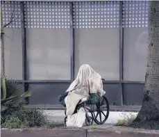  ?? DAMIAN DOVARGANES/AP ?? A homeless person sits in a wheelchair during a storm April 6 in Los Angeles. When census takers tried to count the homeless, they ran into problems.