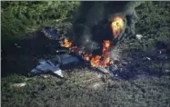  ?? WLBT-TV VIA AP ?? In this frame from video, smoke and flames rise from a military plane that crashed in a farm field, in Itta Bena, Miss., killing several.