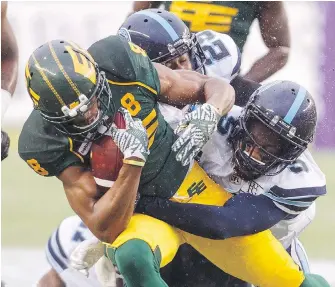  ??  ?? Eskimos receiver Kenny Stafford tries to break away from Argonauts defender Jermaine Gabriel during first-half action in Edmonton on Friday.