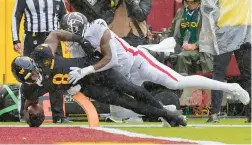  ?? ALEX BRANDON/AP ?? Commanders running back Brian Robinson Jr., left, scoring a touchdown while being tackled by Falcons linebacker Mykal Walker during the first half Sunday, recorded his first 100-yard rushing game in the 19-13 win.