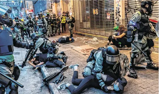  ??  ?? On edge: Protesters are arrested by police during a clash in Hong Kong