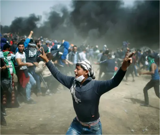  ??  ?? PALESTINIA­NS ATTEND a mass protest on the Gaza border.