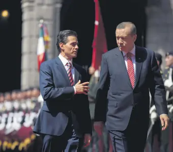  ??  ?? Mexican President Enrique Pena Nieto (L) speaks with Turkish President Recep Tayyip Erdoğan as they walk past an honor guard during a welcome ceremony at the National Palace in Mexico City, Mexico, Feb. 12, 2015.