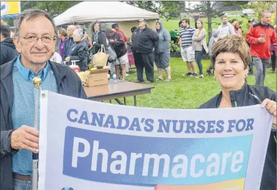  ?? .*5$) ."$%0/"-% 5)& (6"3%*"/ ?? Carl Pursey, president of the P.E.I. Federation of Labour, and Mona O’Shea, president of the P.E.I. Nurse’s Union, hold up a flag advocating for a national pharmacare plan during the Labour Day picnic at Joe Ghiz Park on Monday. More informatio­n on the...