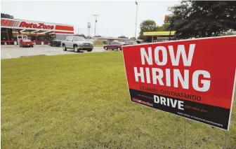  ??  ?? APPLY WITHIN: A bilingual help wanted sign is posted outside an Auto Zone auto parts and accessorie­s store in Canton, Miss., last month.