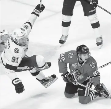  ?? Charles Rex Arbogast Associated Press ?? STEVE STAMKOS, left, of the Lightning is sent f lying after colliding with Teuvo Teravainen (86) of the Blackhawks in the third period of Game 3 in Chicago. Overall, Tampa Bay had the edge in hits, 46-27.