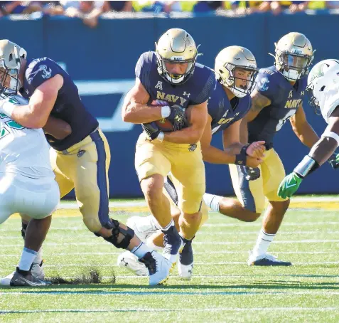  ?? PAUL W. GILLESPIE/CAPITAL GAZETTE ?? Navy fullback Isaac Ruoss, running through a hole in the second quarter Saturday against Marshall, had 63 yards on 15 carries to help the Midshipmen’s rushing attack finish with 337 yards on the ground.