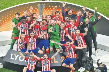  ?? EPA ?? Atletico Madrid players celebrate with the Europa League trophy in Lyon.